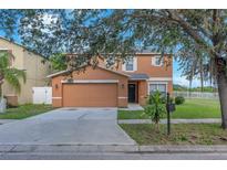 Charming two-story home with a two-car garage and manicured lawn at 10523 Boyette Creek Blvd, Riverview, FL 33569