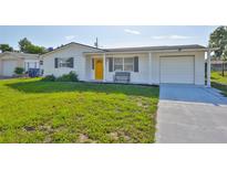 Charming single story home features a bright yellow front door and attached garage at 1426 Gerard Ln, Holiday, FL 34690