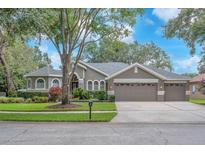 Charming single-story home with three-car garage and well-manicured landscaping at 15206 Merlinpark Pl, Lithia, FL 33547