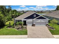 Beautiful one story home with a manicured lawn, lush landscaping, and a brick paver driveway at 1846 Moorhen Way, Lutz, FL 33558
