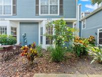 Inviting home exterior with blue siding, manicured landscaping and quaint patio seating at 290 Winchester Way, Palm Harbor, FL 34684