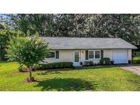 Charming one-story home with a well-maintained lawn and manicured landscaping at 31096 Inwood Cir, Brooksville, FL 34602