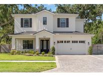 Beautiful two-story white home featuring black shutters, well-manicured lawn, and spacious two car garage at 4114 W Neptune St, Tampa, FL 33629
