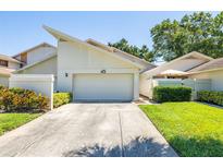 Inviting exterior showcasing a well-maintained facade, garage, and landscaped front yard of home number 45 at 498 Lakeview Dr # 45, Palm Harbor, FL 34683