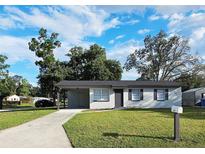 Charming single-story home with well-maintained lawn, covered carport, and tidy landscaping at 8017 Tudor Pl, Tampa, FL 33610