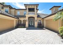 Elegant two-story home with a spacious driveway and a beautiful facade with tan siding and tile roof at 8707 Silverthorn Rd, Seminole, FL 33777