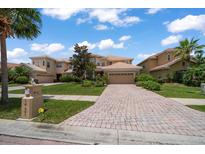 Charming two-story home featuring a tile roof, brick driveway, and well-manicured landscaping at 10921 Cory Lake Dr, Tampa, FL 33647