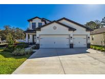 Beautiful two-story home featuring a three car garage and manicured front lawn at 11311 Striped Bass Ct, New Port Richey, FL 34654