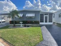Charming single-story home with a well-manicured lawn, beautiful landscaping, and a covered parking area at 124 Saint Pierres Way, Apollo Beach, FL 33572
