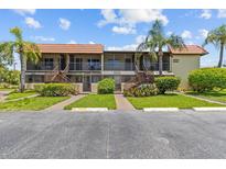 Condominium exterior with palm trees, green grass and landscaping at 2420 Winding Creek Blvd # 209, Clearwater, FL 33761
