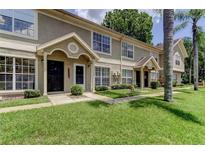 Inviting townhouse exterior features a well-maintained lawn and neutral color scheme at 2898 Thaxton Dr # 76, Palm Harbor, FL 34684