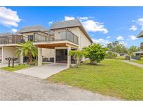 Two-story townhome with a balcony, carport, and well-maintained lawn and landscape at 3368 Ramblewood Pl # 37-D-1, Sarasota, FL 34237