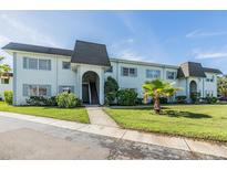 Two-story condo complex with lush landscaping and a well-manicured lawn at 387 S Mcmullen Booth Rd # 16, Clearwater, FL 33759