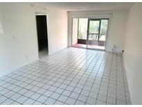 Bright living room featuring tile floors, neutral walls, and sliding glass doors to a screened lanai at 6342 Newtown Cir # A4, Tampa, FL 33615
