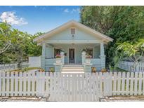 Charming bungalow with a picket fence, lush landscaping, and welcoming front porch at 1415 7Th N Ave, St Petersburg, FL 33705