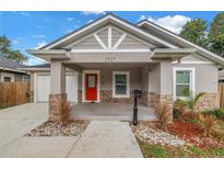Charming single-story home featuring a bright red door, stone accents, and well-manicured landscaping at 1717 Preston S St, St Petersburg, FL 33712