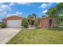 Charming single-Gathering home showcasing a well-manicured lawn and vibrant landscaping at 1741 Font Ln, Holiday, FL 34691