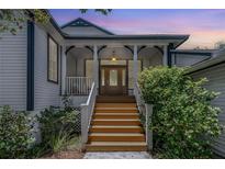 Charming home with a welcoming front porch and beautiful wood stairs at 389 Grand Bay Dr, Palm Harbor, FL 34683