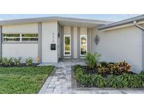 Inviting home entrance with manicured landscaping, modern exterior, and a brick walkway at 4015 Overlook Ne Dr, St Petersburg, FL 33703