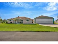Charming single-story home with a well-manicured lawn and large airplane hangar at 11908 Pilot Country Dr, Spring Hill, FL 34610