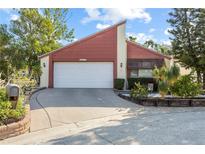 Inviting home featuring an attached two-car garage and well-manicured landscaping at 12234 Cider Mill Ln, Hudson, FL 34667