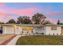 Charming single-story home with freshly painted exterior, landscaped yard, and attached garage with driveway at 1320 Dixie S Ln, St Petersburg, FL 33707