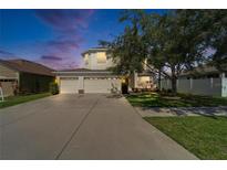 Two-story home with a three car garage, large driveway, and a well-maintained lawn at 13252 Graham Yarden Dr, Riverview, FL 33579