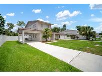Two-story home with a long driveway, carport and well-maintained lawn at 1712 Azalea Ct # A, Oldsmar, FL 34677