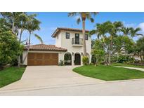 Charming two-story stucco home with a tile roof, arched entry, and lush tropical landscaping at 1960 Kansas Ne Ave, St Petersburg, FL 33703