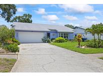 Charming single-story home with a well-manicured lawn, mature landscaping and a two car garage at 1983 Seton Dr, Clearwater, FL 33763