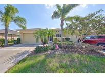 Charming single-story home with palm trees, inviting curb appeal, and a well-maintained lawn in a serene neighborhood at 2239 Sifield Greens Way # 84, Sun City Center, FL 33573