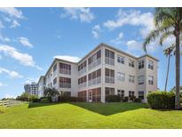 Low-angle exterior of condo building featuring large lawn, screened lanais and lush landscaping at 2725 Terra Ceia Bay Blvd # 104, Palmetto, FL 34221