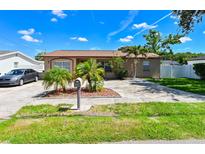 Charming single-story home features a well-manicured lawn and tropical landscaping at 3303 W Idlewild Ave, Tampa, FL 33614