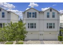 Charming two-story townhouse featuring a two-car garage, neutral color palette, and paver driveway at 3807 W Cleveland St, Tampa, FL 33609