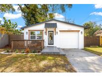 Charming home with a deck, white exterior, modern front door, and a one car garage at 403 E North St, Tampa, FL 33604