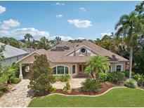 Charming single-story home featuring a beautiful lawn, lush landscaping, and a paver driveway at 4615 Shark Dr, Bradenton, FL 34208