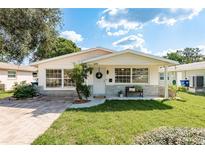 Charming single-story home with well-maintained lawn and inviting front porch seating at 6658 Stewart N Ave, St Petersburg, FL 33702
