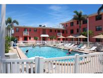 Inviting swimming pool surrounded by lounge chairs and lush landscaping, perfect for relaxation at 6800 Sunset Way # 1708, St Pete Beach, FL 33706