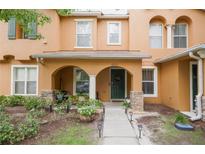 Charming townhome with front porch, archways, and green door in landscaped yard at 6925 Marble Fawn Pl, Riverview, FL 33578