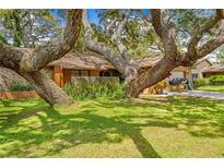 Charming home featuring mature landscaping, stone accents, and a well-maintained lawn at 8268 Garrison St, Spring Hill, FL 34606