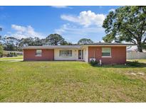 Charming brick home featuring a well-manicured front lawn and classic architectural details at 8310 Pat Blvd, Tampa, FL 33615