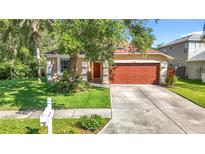 Charming single-Gathering home with a well-manicured front lawn and a two-car garage at 10323 Birdwatch Dr, Tampa, FL 33647