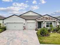 Charming one-story home features a brick-paved driveway and a three-car garage for ample parking at 12351 Nouveau Ave, Spring Hill, FL 34610