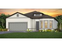 Beautiful single-story home with a gray two-car garage, well-manicured lawn and mature landscaping at 13644 Canyon Ridge Rd, Spring Hill, FL 34610