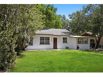 Charming single-story home with a well-manicured lawn and mature trees, creating a welcoming curb appeal at 1512 Hillside Dr, Tampa, FL 33610