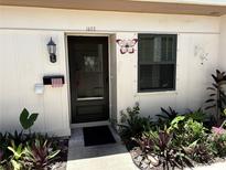 Charming home entrance featuring a well-maintained door, decorative accents, and surrounding greenery at 1605 Mission Hills Blvd # D5, Clearwater, FL 33759