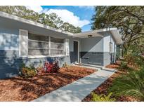 Charming home featuring a neatly landscaped yard and a welcoming front entrance with a well-maintained walkway at 1949 Kings Hwy, Clearwater, FL 33755