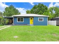 Charming blue home featuring a bright yellow front door and well-maintained lawn at 201 83Rd N Ave, St Petersburg, FL 33702