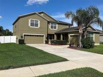 Two-story home with well-maintained lawn, desert landscaping, and a two-car garage plus a one-car garage at 20101 Oakflower Ave, Tampa, FL 33647