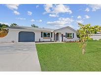 Charming single-story home with a well-maintained lawn and an attached garage at 20390 Lorenzo Ave, Port Charlotte, FL 33952